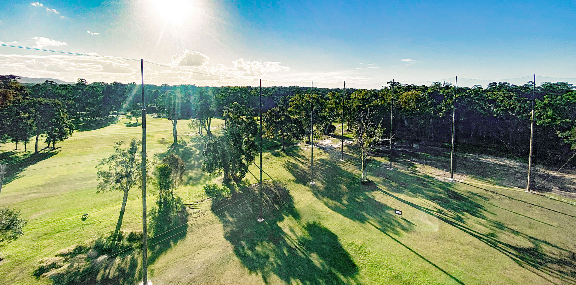 Driving range with netting poles and synthetic turf