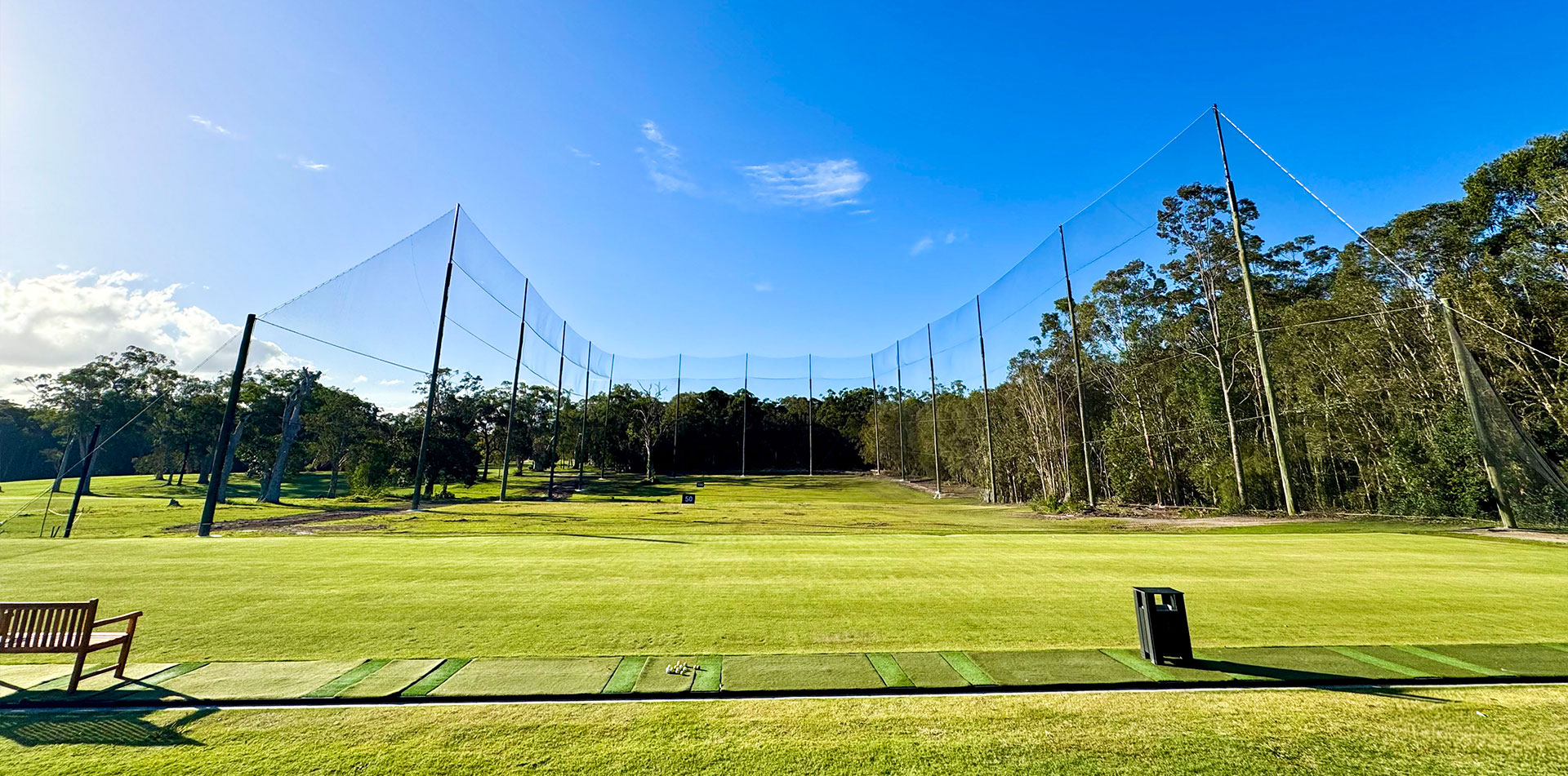 Driving range hitting bays with barrier netting